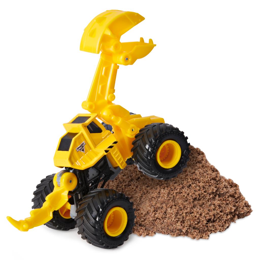 Toy construction vehicle with a scoop driving over dirt