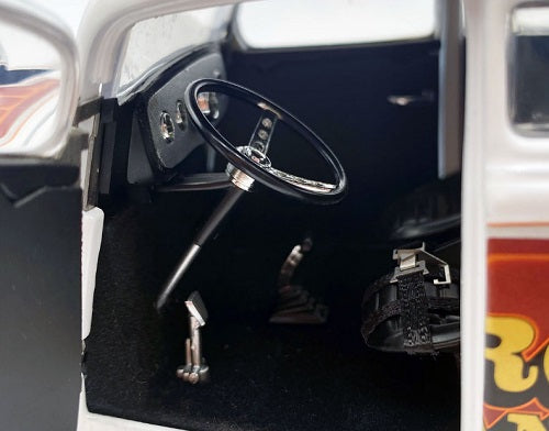 Close-up of a model car's interior with steering wheel and dashboard.