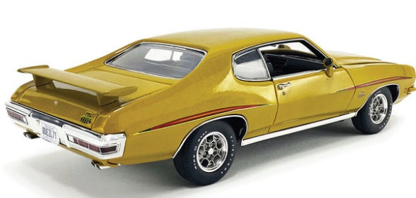 Rear and side view of gold colored car.