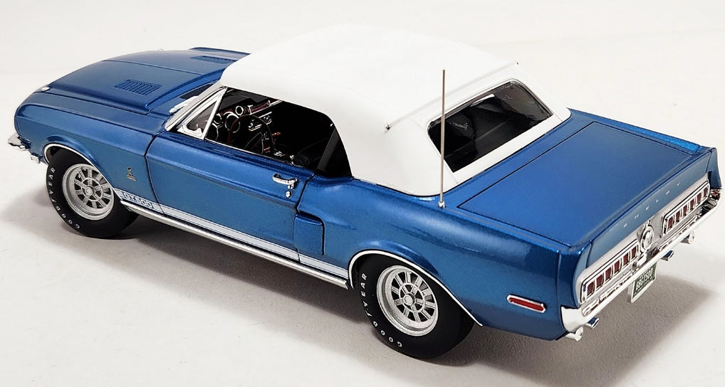 Diecast model car of a blue 1968 Shelby GT500 Convertible with closed white roof.