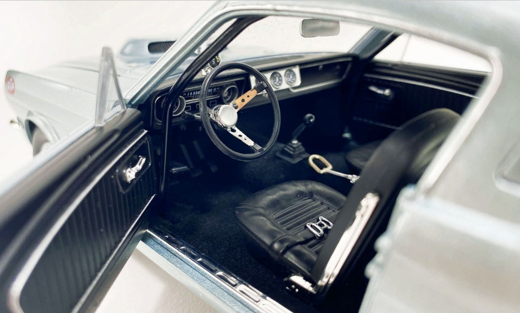Interior view of drivers side seat, steering wheel, and dashboard.