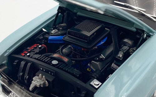 Model of car engine compartment with visible components and branding.