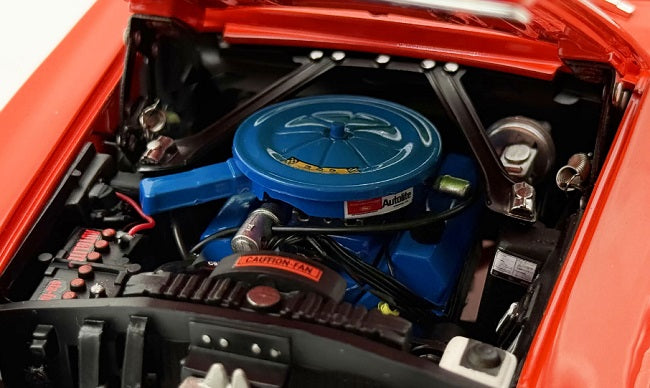 Close-up of a red car engine with a blue air filter and visible brand logo.