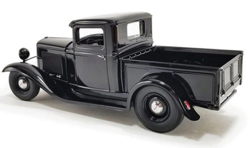 Rear, side view of old black truck.