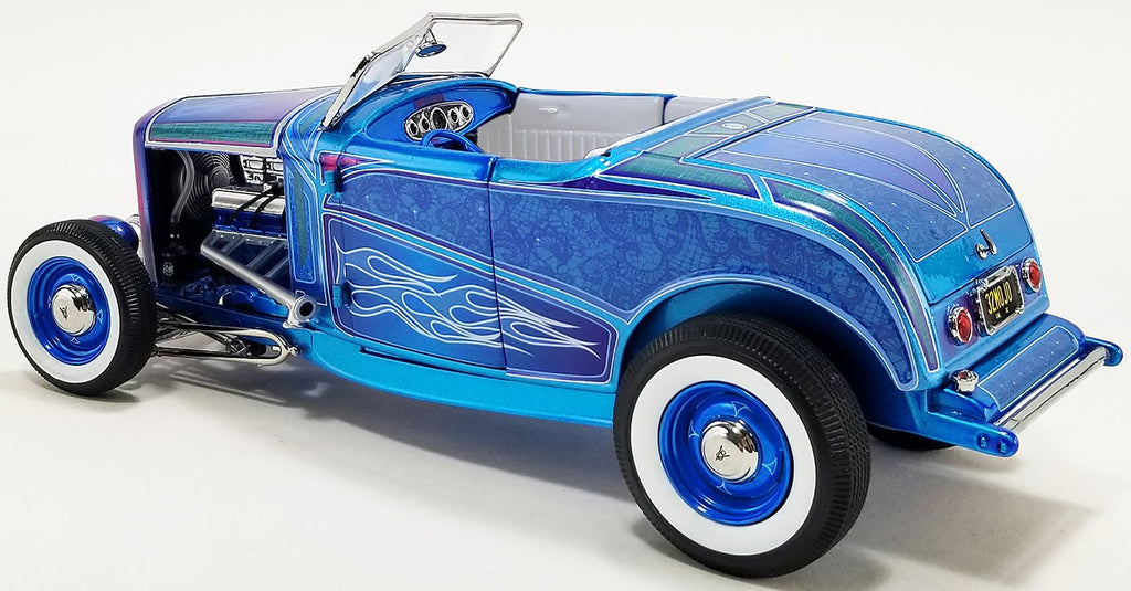 A 1/18 scale model of a 1932 Ford Hot Rod Roadster in blue flame color with white wall tires and blue steelie wheels.