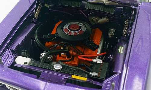 Close-up of a model car's open hood revealing the engine and battery.
