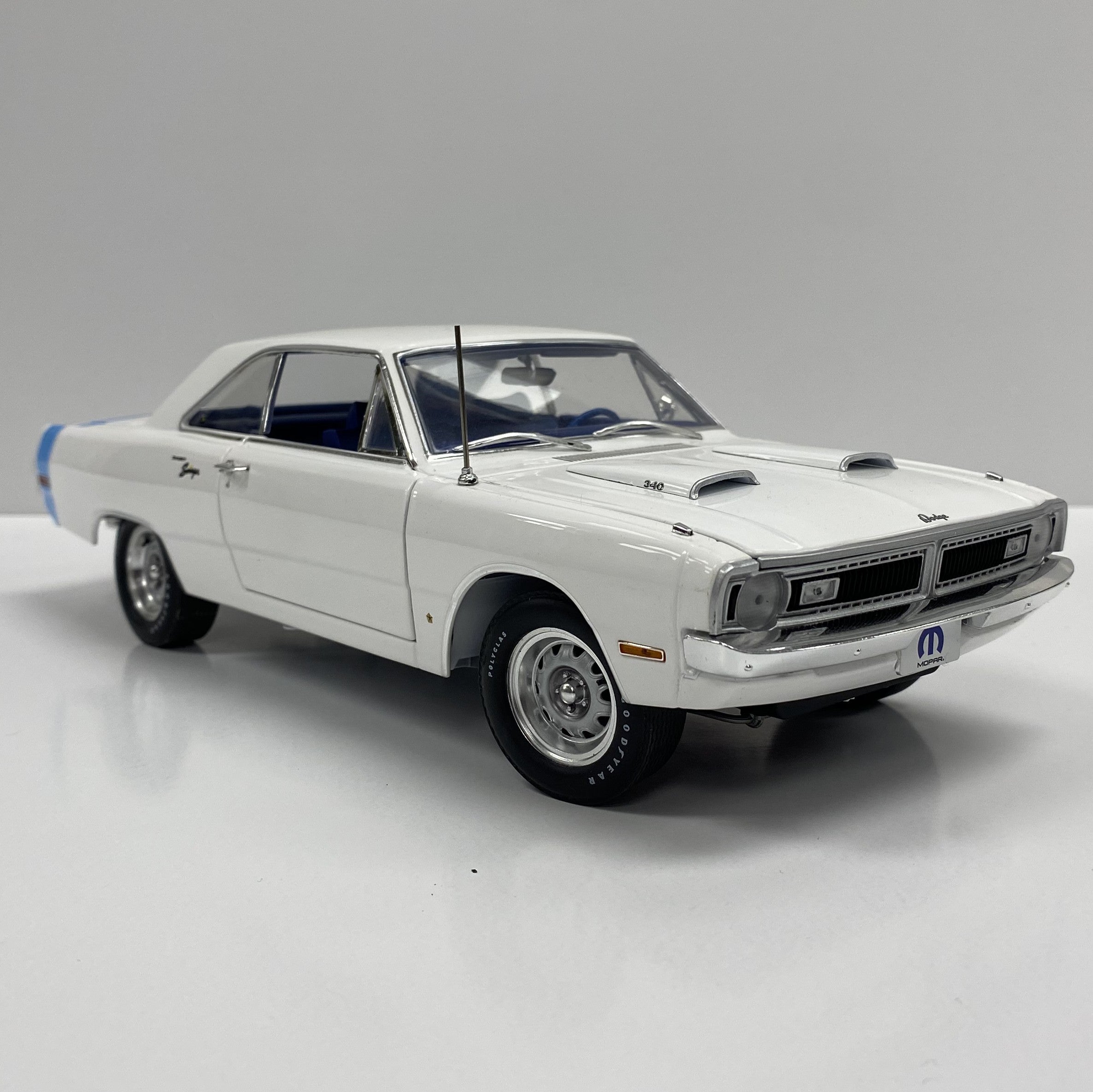 Scale model of 1970 Dodge Dart Swinger in white with blue stripe.
