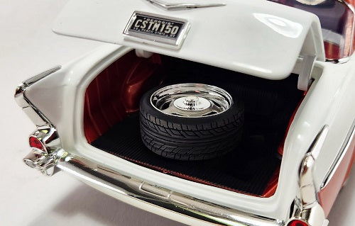 Model car with open trunk revealing a spare tire on a white background