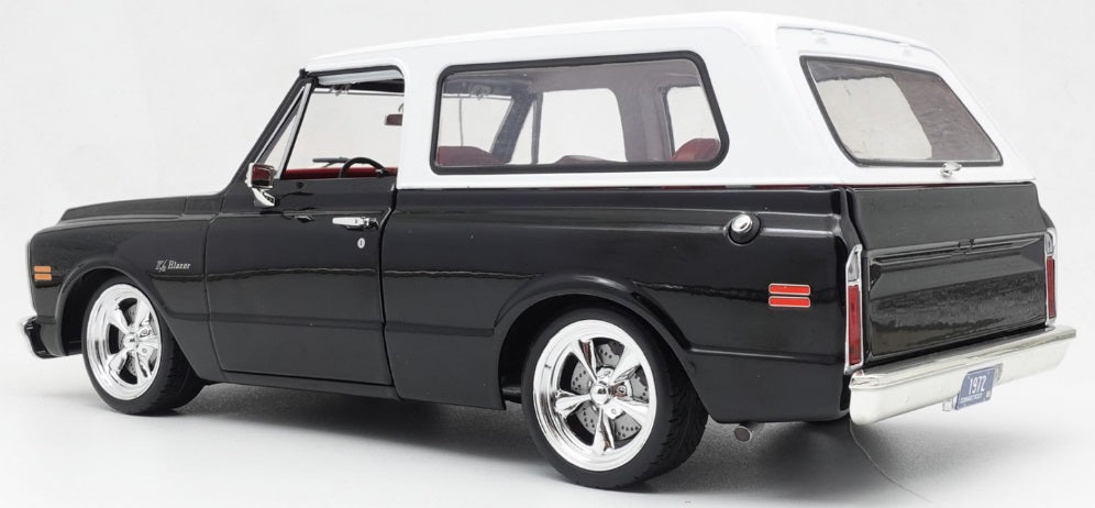 Rear and side view of black Chevy Blazer with white roof.