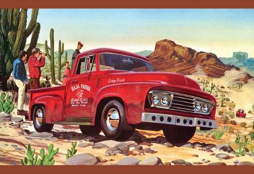Red truck in a desert setting with cacti and mountains and two people standing behind.