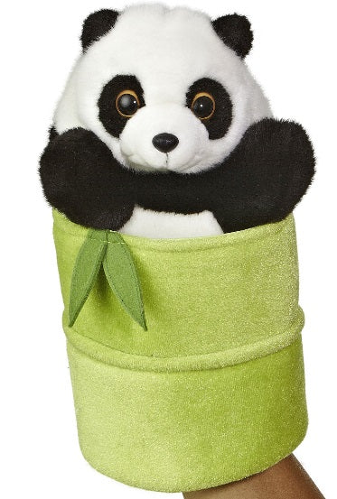 Plush toy panda sticking out of a large bamboo piece.