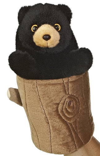 Plush Black bear sticking out of fake tree stump.