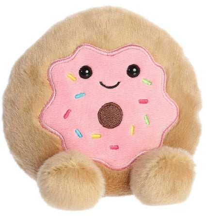 A plush toy of a donut with pink icing, colorful sprinkles, and a smiling face.