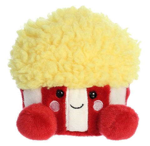 Plush toy of a red and white bucket with fluffy "popcorn" overflowing from the top and a smiling face.