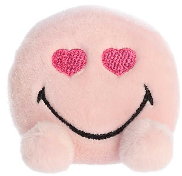 Pink plush smiley face with hearts for eyes and two small feet.