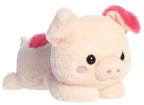 A plush toy resembling a pig with a pink blush on its face, pink ears, and a pink outfit, lying down and smiling.