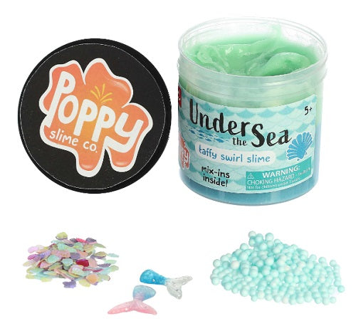 A jar of 'Under the Sea Slime' with light green and blue hues, accompanied by small mix-in pieces such as glittery seashell sprinkles and plastic mermaid tails.