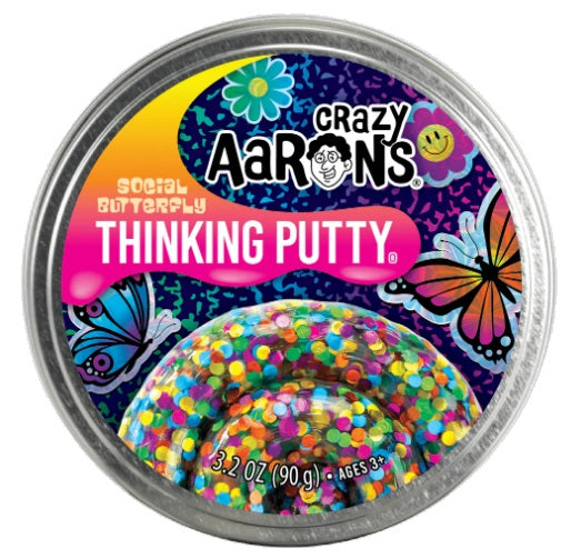 Round metal tin with flower and butterfly pictures and putty with colorful circles mixed in.