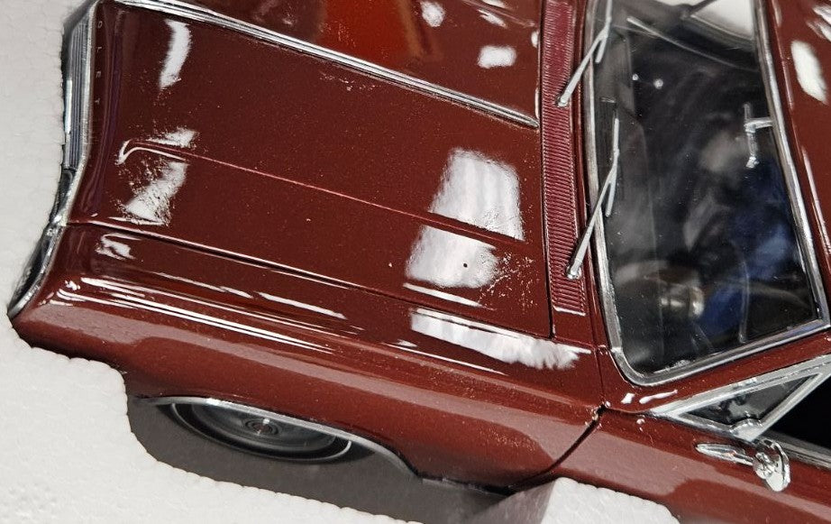 1/18 scale model of a 1965 Chevrolet El Camino in burgundy color with blemished paint.