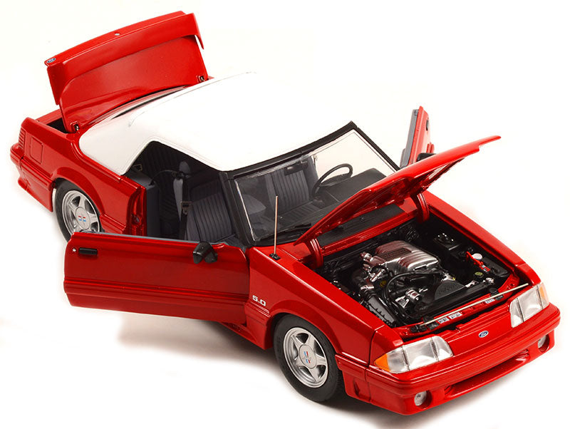 A 1/18 scale diecast model of a red 1991 Mustang GT Convertible showing open doors, hood, and trunk.