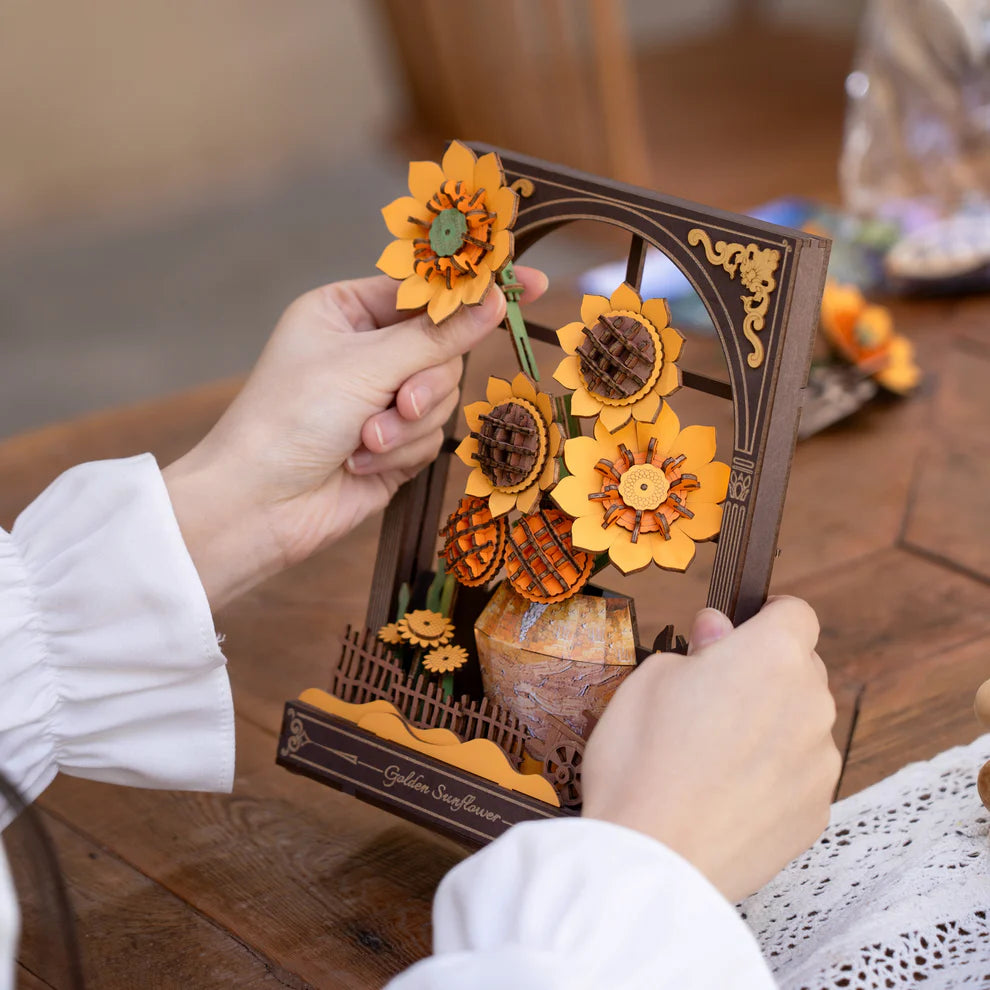 Two hands assembling the Golden Sunflower kit 