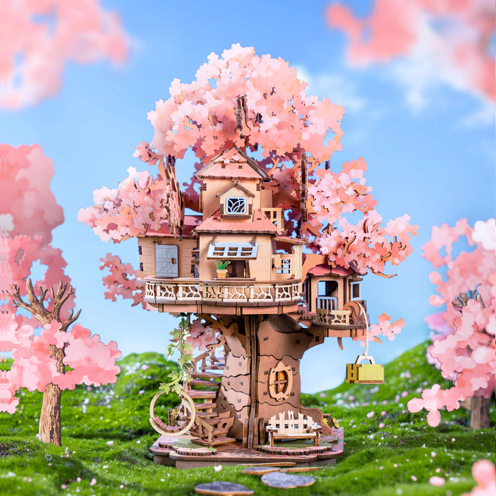 Wooden treehouse model with cherry blossom trees in a scenic setting