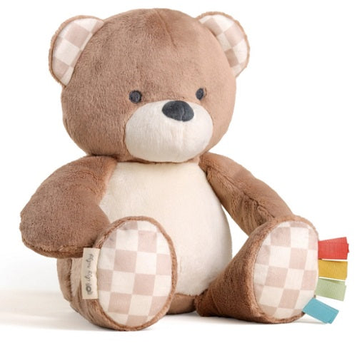 Plush teddy bear with checkered feet on a white background