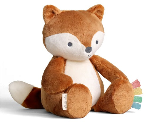 Plush brown fox toy with white details on his belly, tip of his tail, and his face with colorful ribbons on his foot.