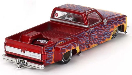 1/64 scale model of a Chevy Silverado red with yellow, orange, and blue flames and lowrider chassis.