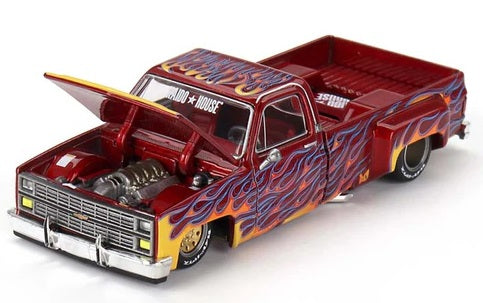 1/64 scale model of a Chevy Silverado red with yellow, orange, and blue flames and lowrider chassis.