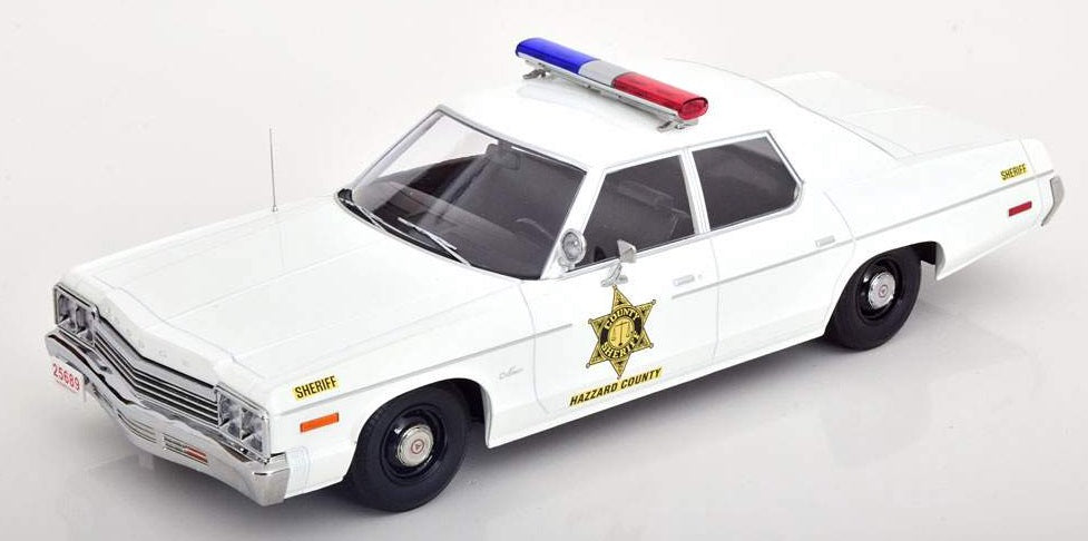 A 1/18 scale model of a 1974 Dodge Monaco Hazzard County Police Sheriff car in white color with red and blue light bar on roof.