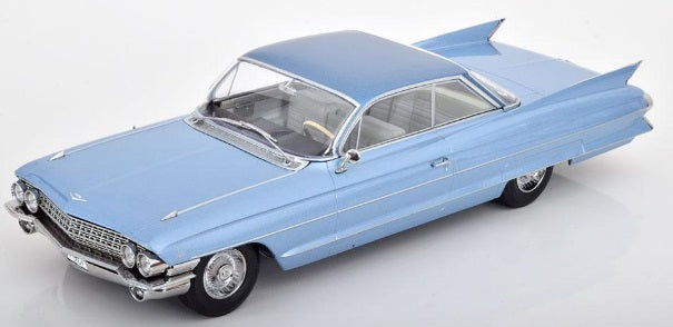 A 1/18 scale model of a 1961 Cadillac Series 62 Coupe DeVille in light blue metallic color.