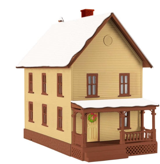 A model of Billy's house from the movie 'The Polar Express', featuring a light-colored exterior, dark windows, and a snow-covered roof.