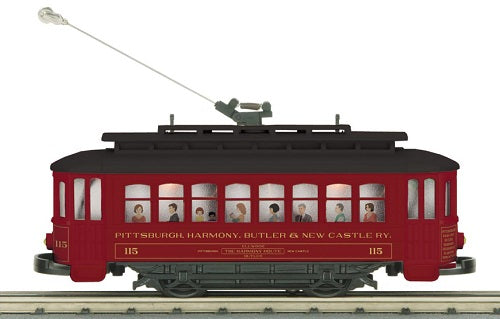Model of a maroon trolley with pictures of people in the windows.