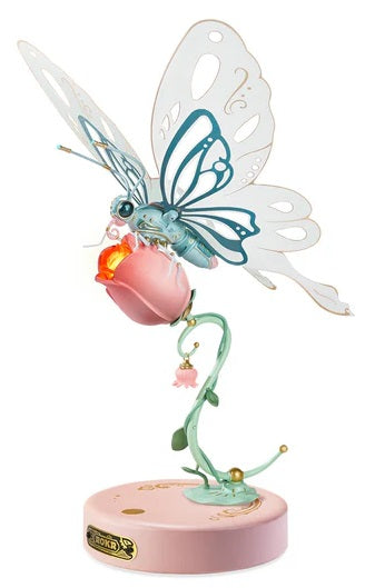 A mechanical model kit of a pink butterfly with blue and rose pink wings, perched on a base that resembles a twisted rose with vines.