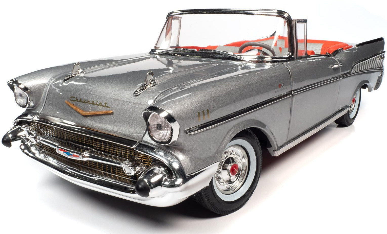A 1/18 scale model of a 1957 Chevrolet Bel Air Convertible in silver color and red interior