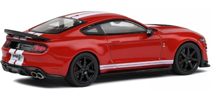 A 1/43 scale model of a red 2020 Ford Shelby Mustang GT500 with black rims and white stripes.