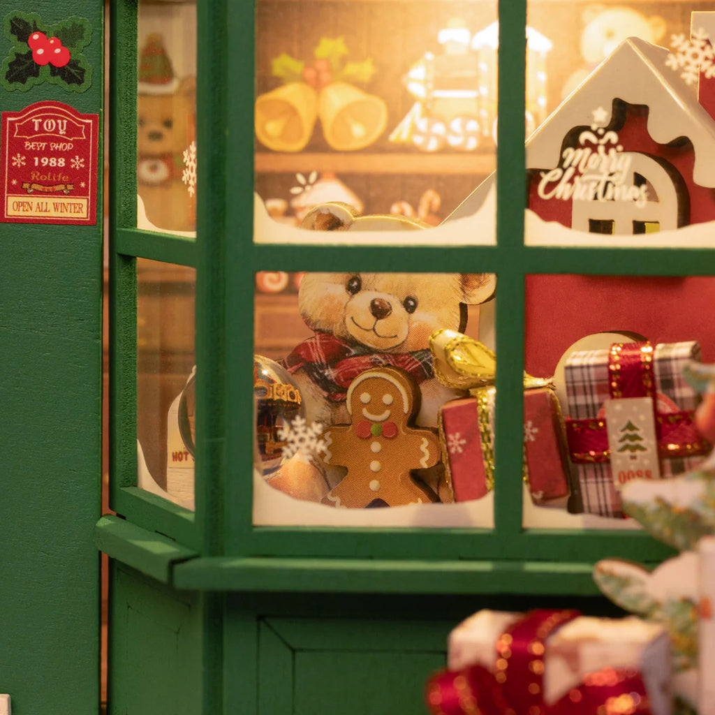 Close up of window display showing a bear and presents through a green window.