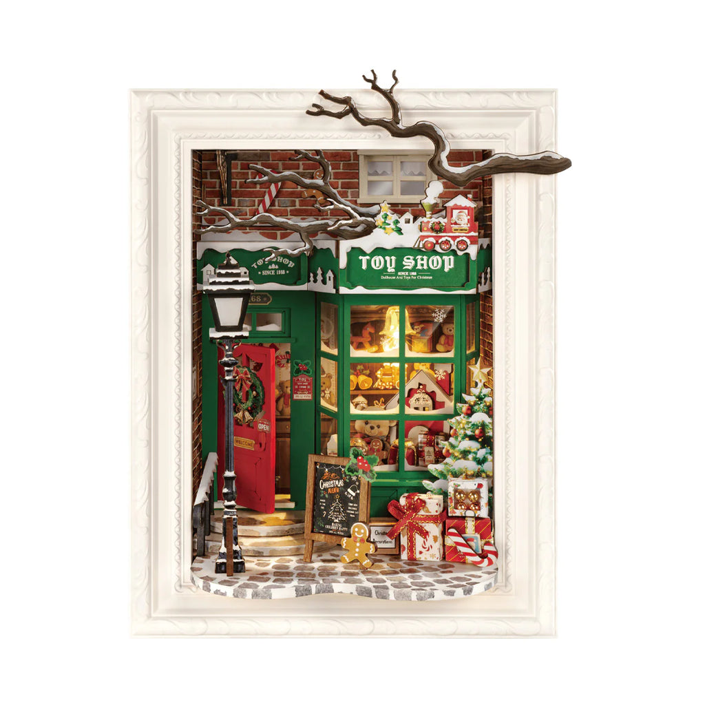 Miniature toy shop scene with Christmas decorations inside a framed picture.