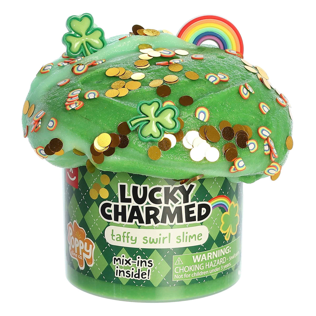 A jar of green slime decorated with shamrocks and miniature gold coins, labeled 'LUCKY CHARMED taffy swirl slime' with a rainbow and pot of gold design elements.