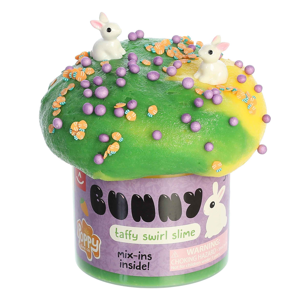 A container of Bunny Slime with green and yellow taffy swirl slime, with carrot shapes, purple balls, and two white bunnies figures to mix in to the putty.