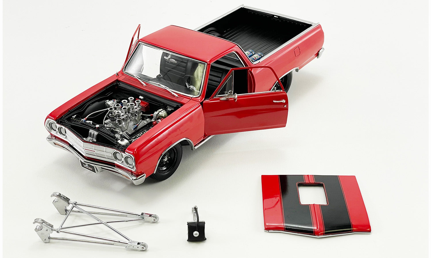 Red and black 1/18 scale model of a 1965 El Camino, showing open doors, hood removed and other detail parts pictured next to the car.
