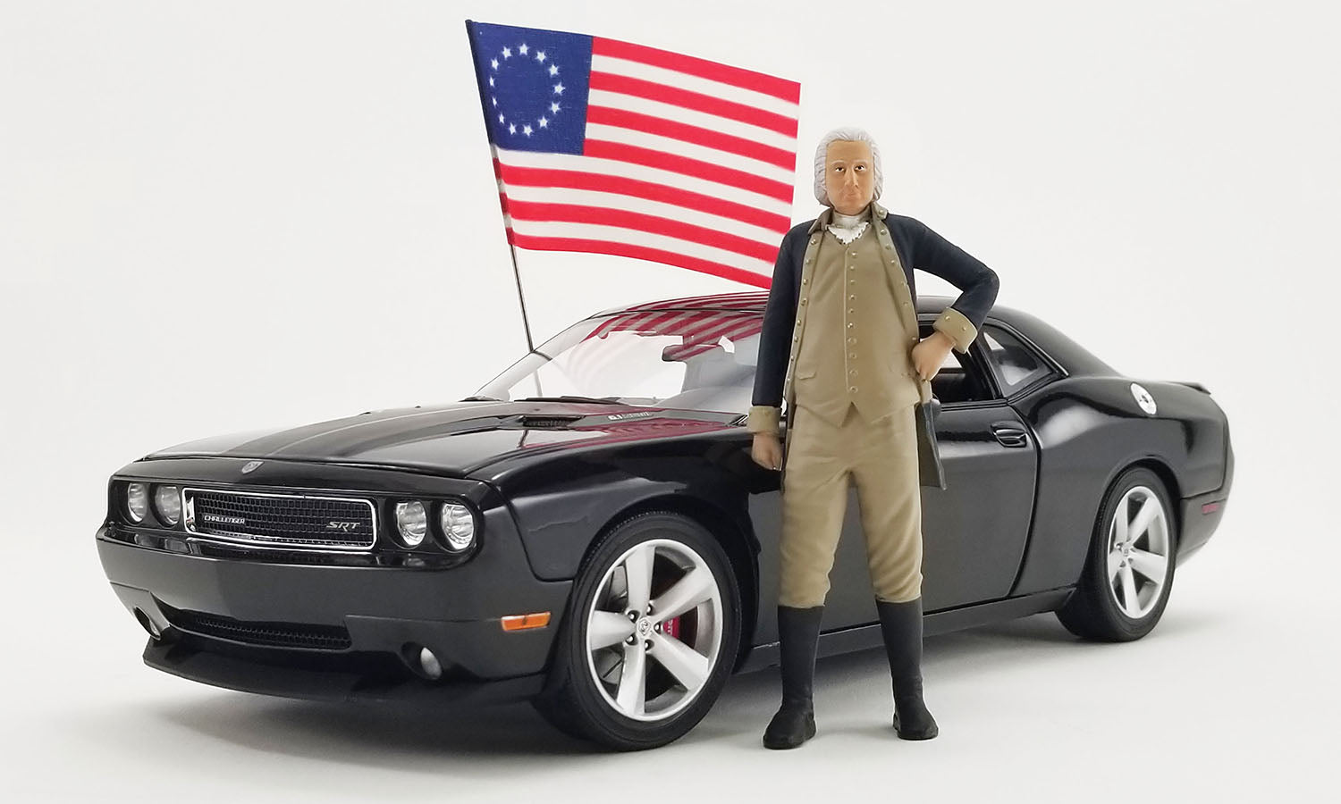 Model of 2010 Dodge Challenger with figure of George Washington and a flag.