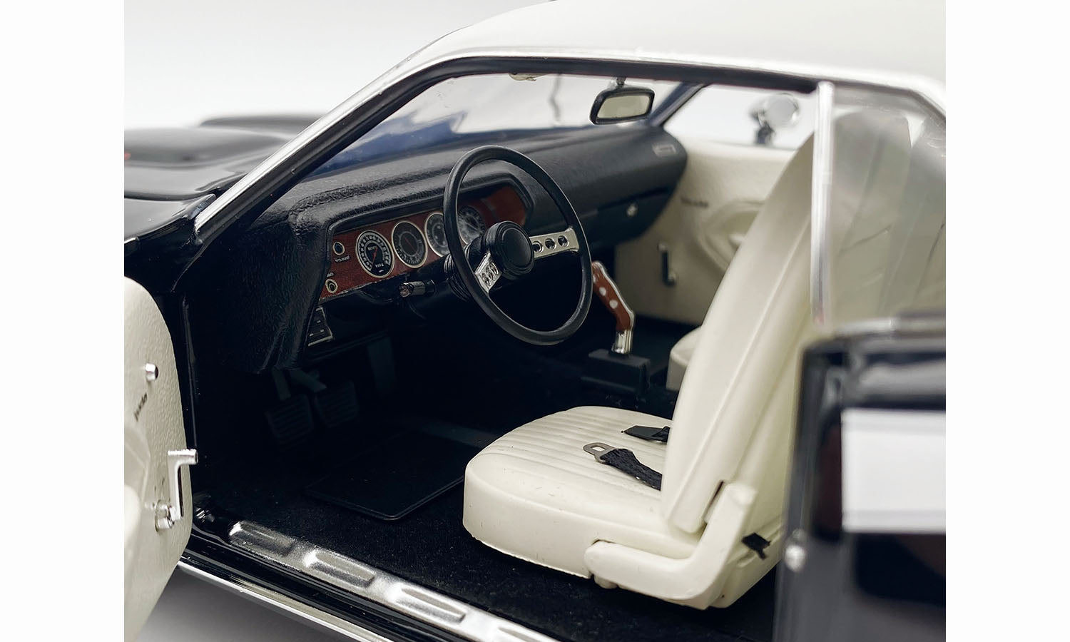 Interior view of 1/18 scale model car in black with white seats.