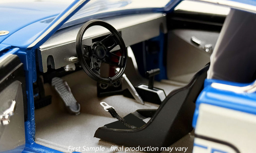 Close-up of a model car's interior with steering wheel and dashboard.