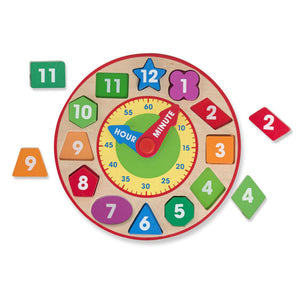 Melissa and Doug Clock, each number is a chunky puzzle piece each a unique color and shape, that fits into the clock, hour and minute hand are labeled, and a smaller clock face showing the numbers for minutes, labeled in increments of 5