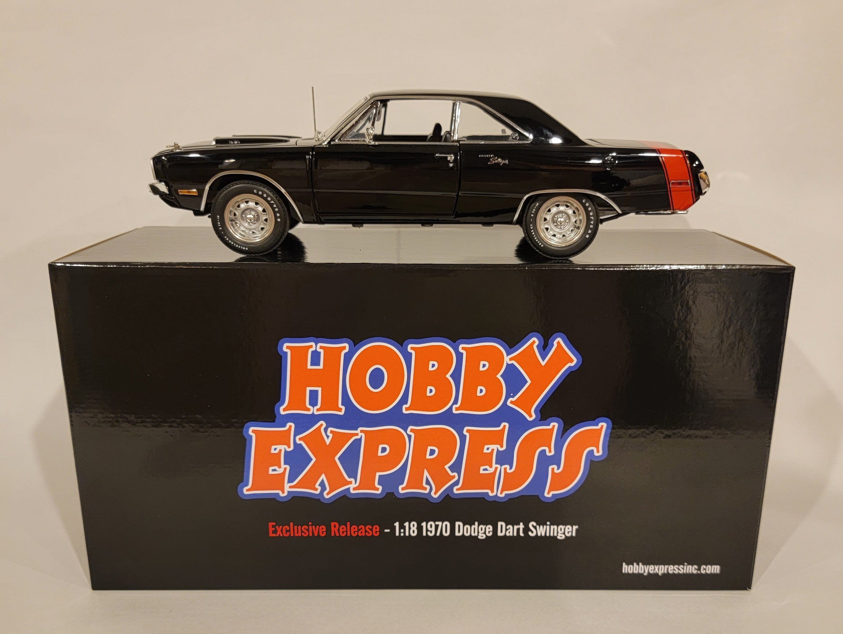 A 1/18 scale diecast model of a 1970 Dodge Dart Swinger 340 with a red tail stripe, displayed on top of its black box packaging labeled 'Hobby Express Exclusive'.