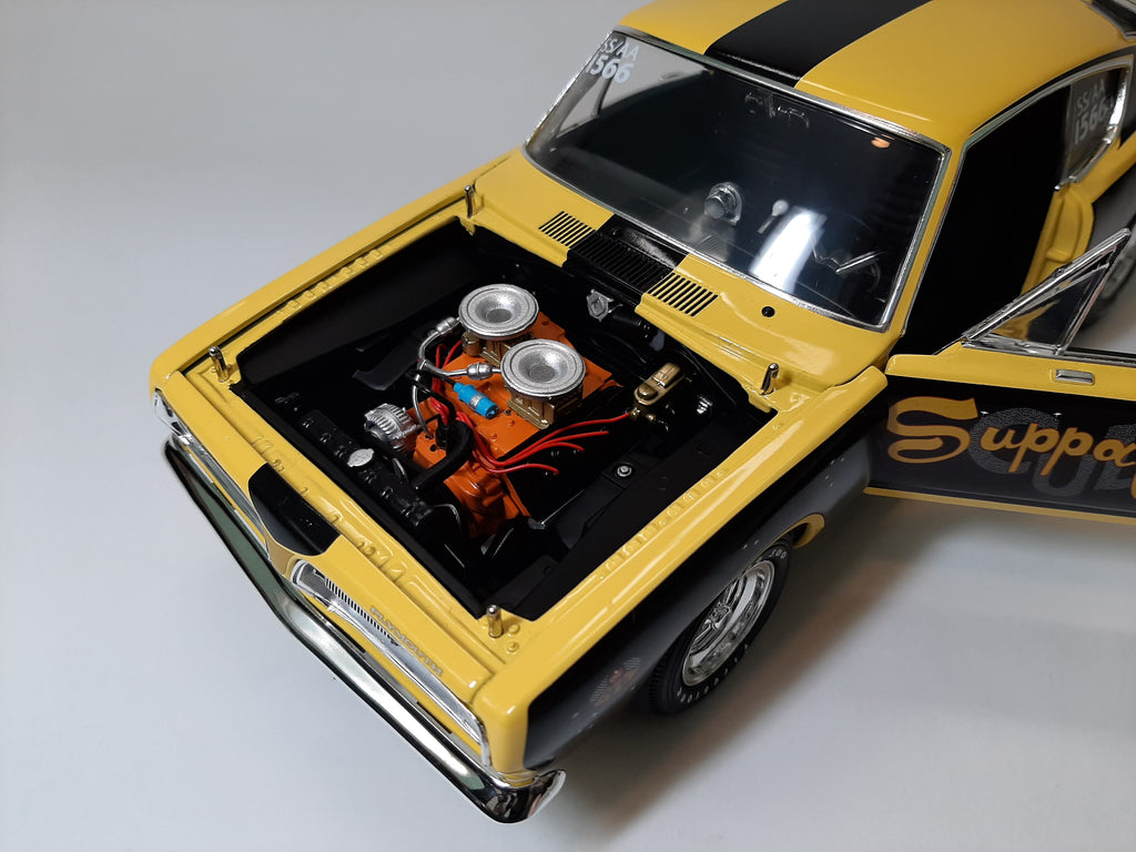 A 1/18 scale mode of 1968 Barracuda that is black and yellow with hood removed.