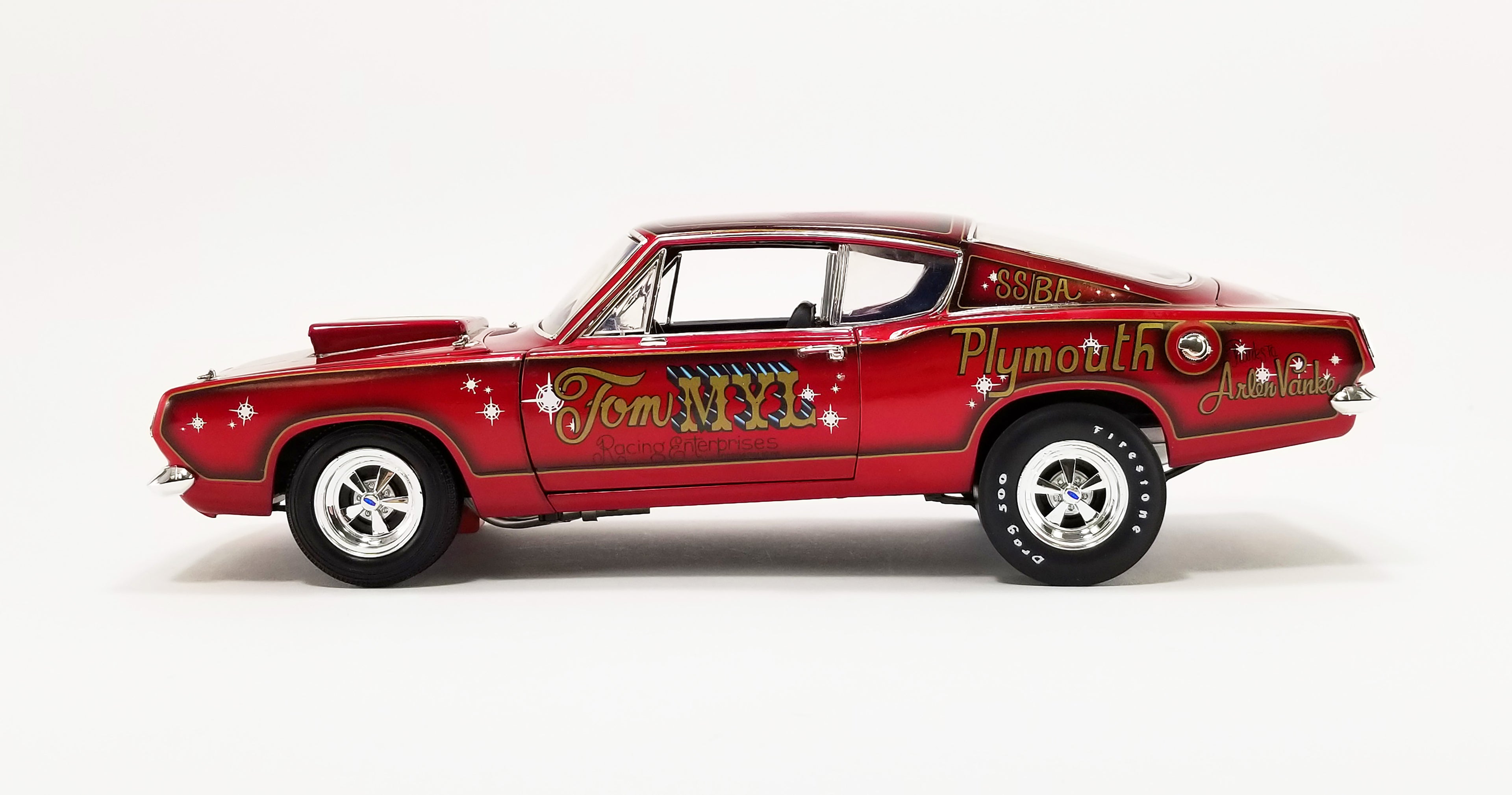 A 1/18 scale model of a 1968 Plymouth Barracuda race car, predominantly red with Gold and black detailing, labeled 'Tom Myl' and 'Plymouth'.