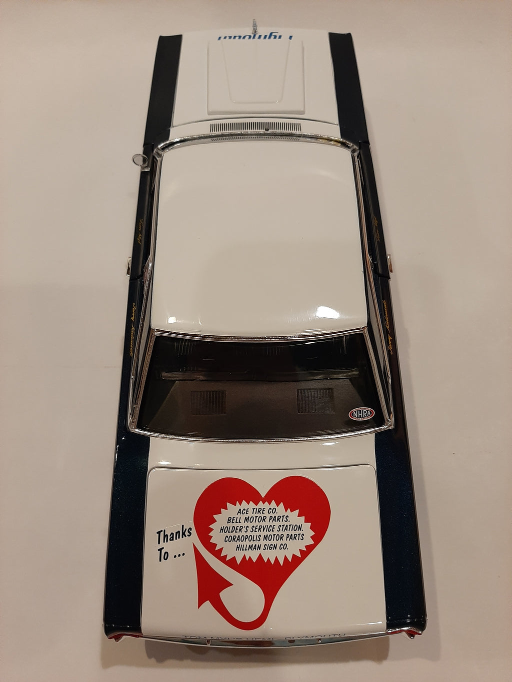 A 1/18 scale model of a 1967 Plymouth Belvedere in white with blue and black detailing, resembling a racing car with sponsor decals.